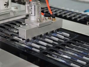 Máy ép vỉ ống tiêm với hệ thống cấp ống tiêm tự động.